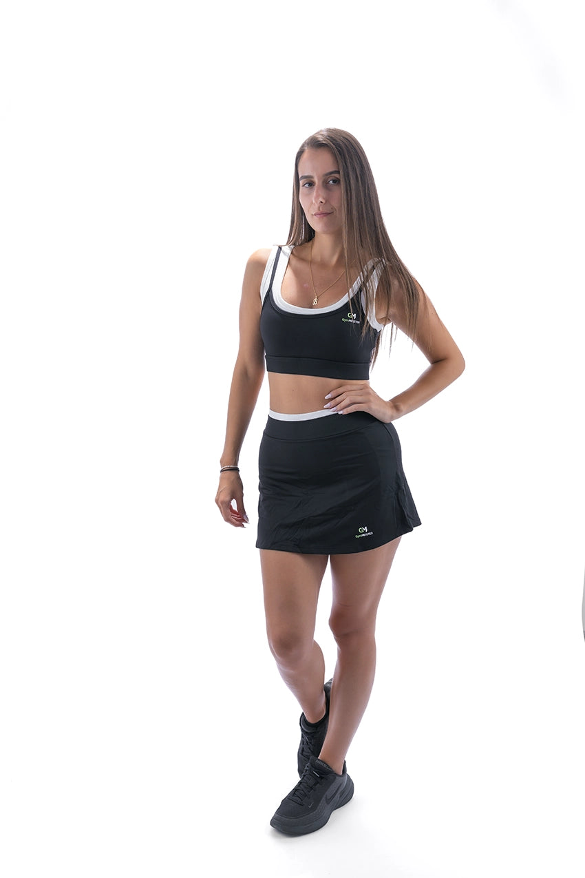 Модел с GymMeister Vela кроп топ и Halo къса спортна пола в матов оникс